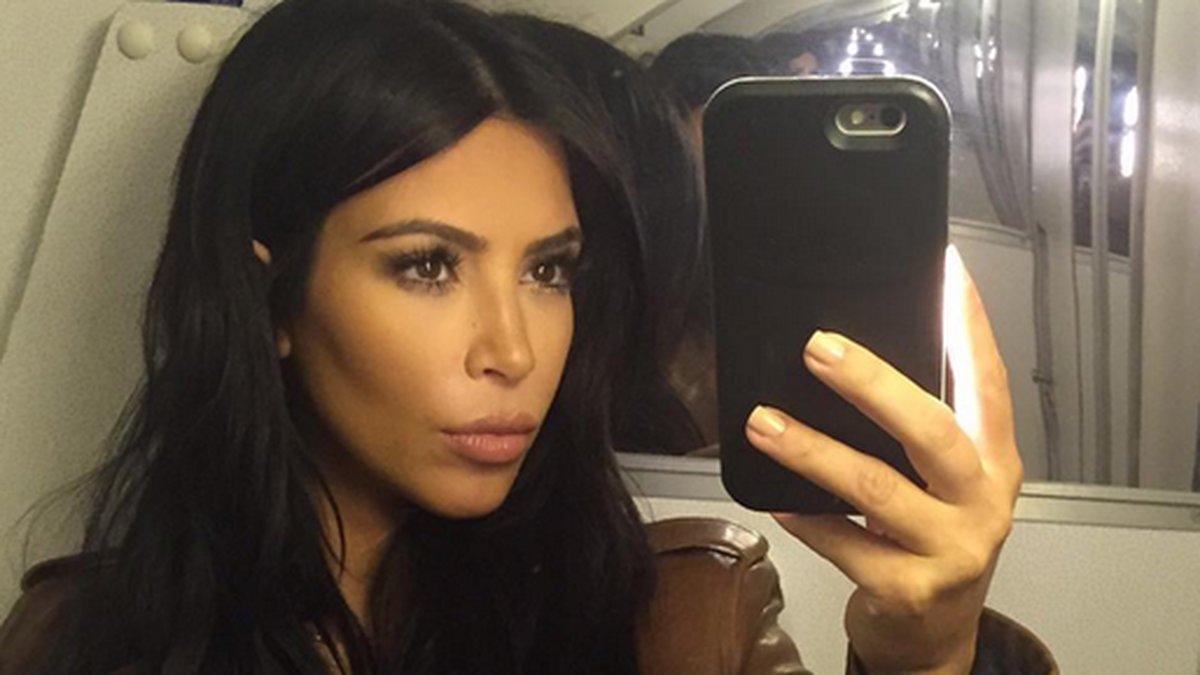 Kim Kardashian tar en selfie på flyget. 